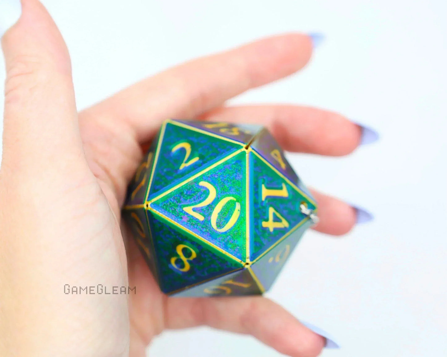 Hand holding a holographic green and gold twenty-sided dice car charm