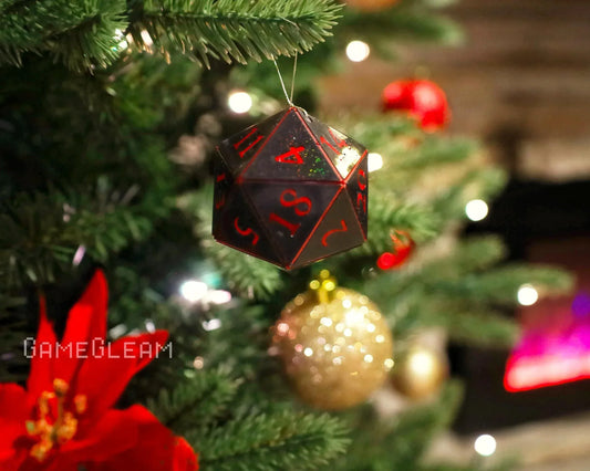 Black and red twenty-sided dice ornament hanging on a decorated Christmas tree.