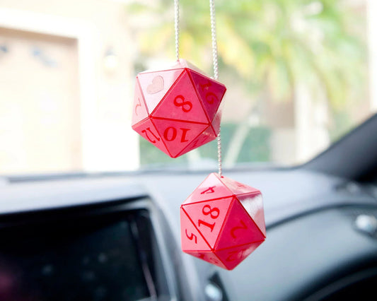 Handmade red twenty-sided dice car mirror charms hanging in a vehicle interior