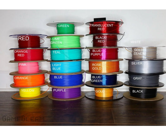 Multiple spools of colorful crafting wire labeled by color, including red, blue, green, gold, and silver.