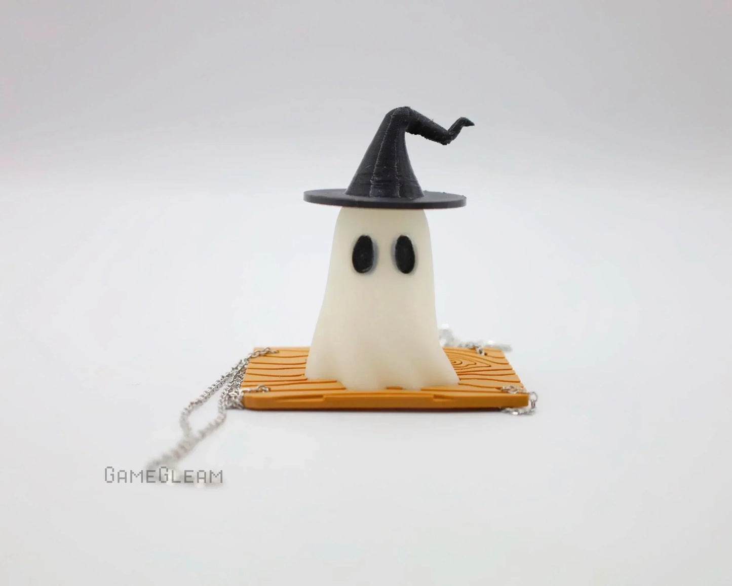 Handmade ghost figurine with witch hat on a wood-patterned base, silver chain accessory