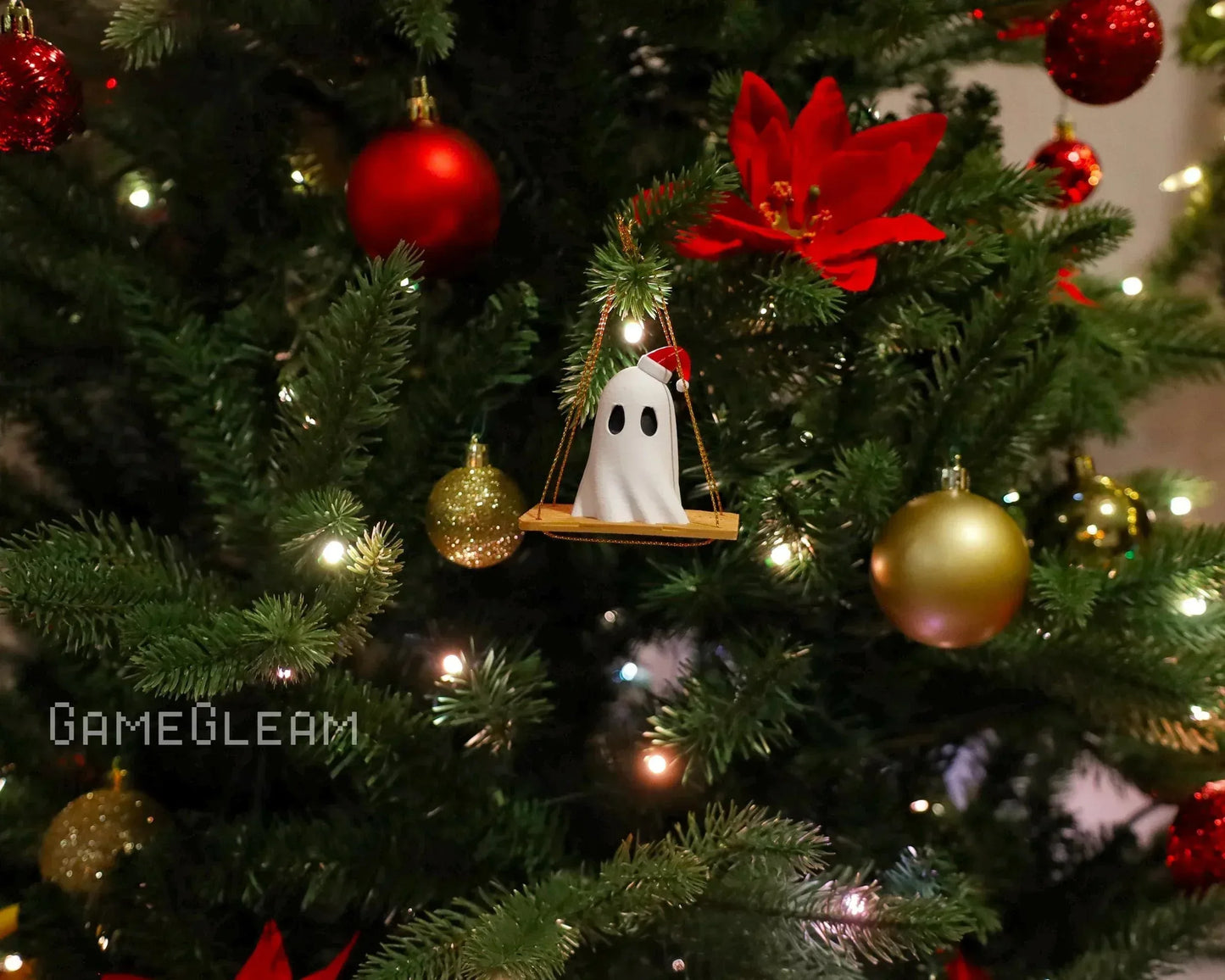 Handmade ghost ornament with Santa hat on swing hanging on decorated Christmas tree