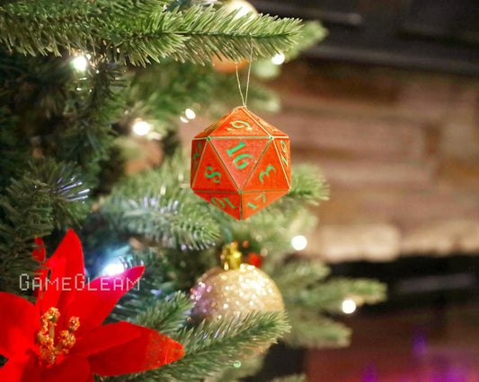 Red twenty-sided dice ornament with green numbers hanging on a Christmas tree with festive lights.
