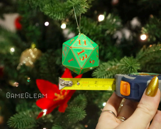 Green twenty-sided dice ornament hanging on a Christmas tree, measured with tape measure