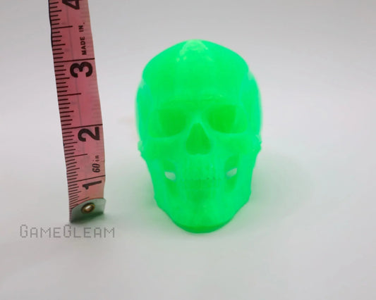 Neon green resin skull figurine with measuring tape on white background