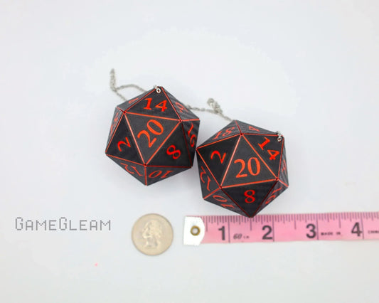 Black and red twenty-sided dice car charm with chain, shown next to a ruler and coin for scale.