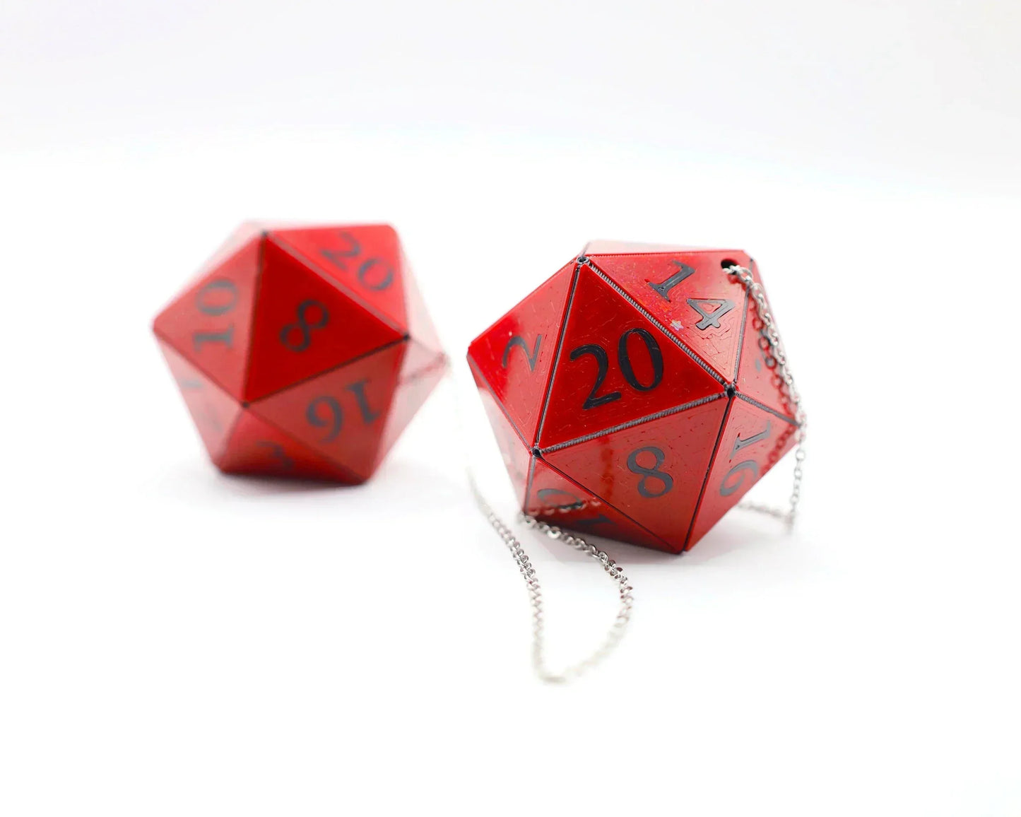 Red handmade twenty-sided dice car charms with metallic chains on white background