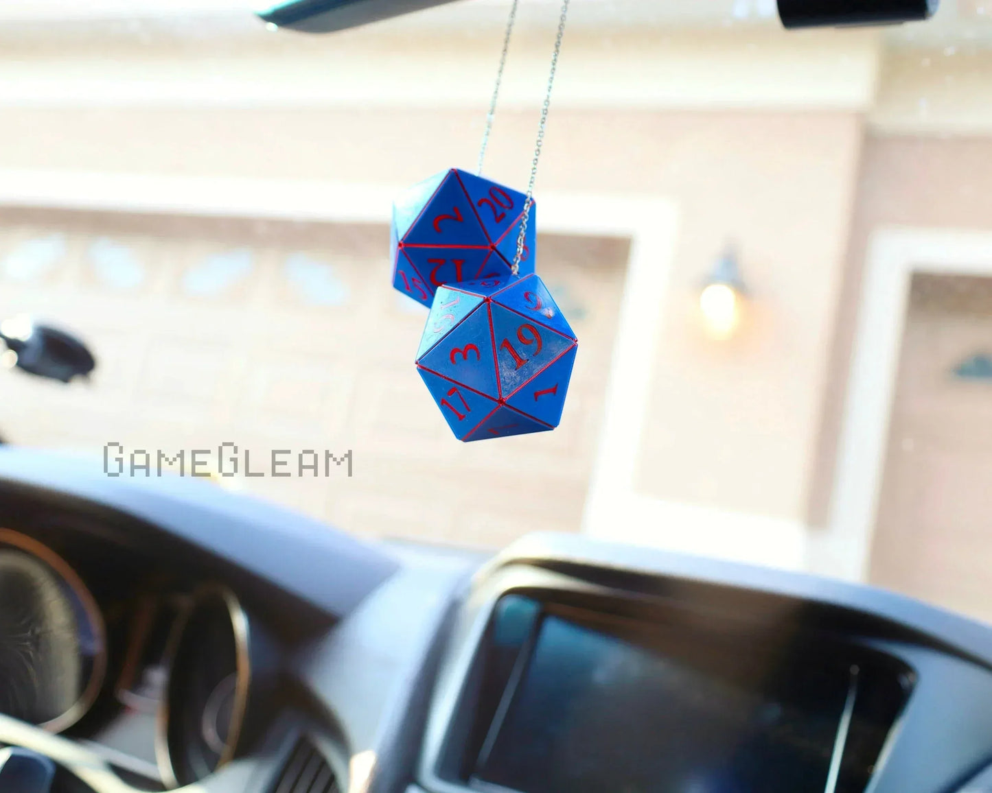 Blue twenty-sided dice car charm with red numbers hanging from rear view mirror, gamer decor