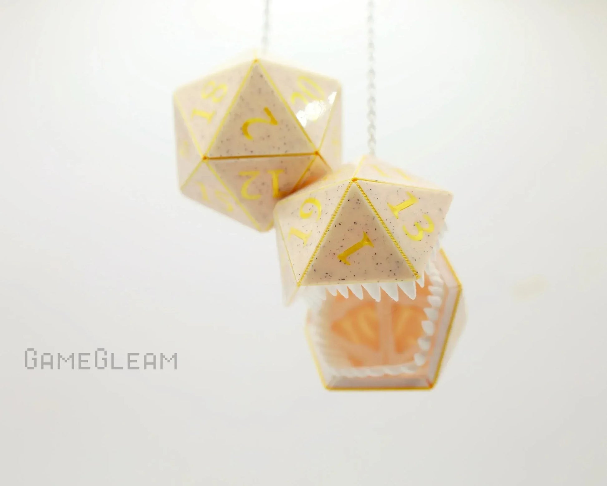 Handmade cream and yellow 20-sided dice charms with teeth, hanging on a chain, for gamers