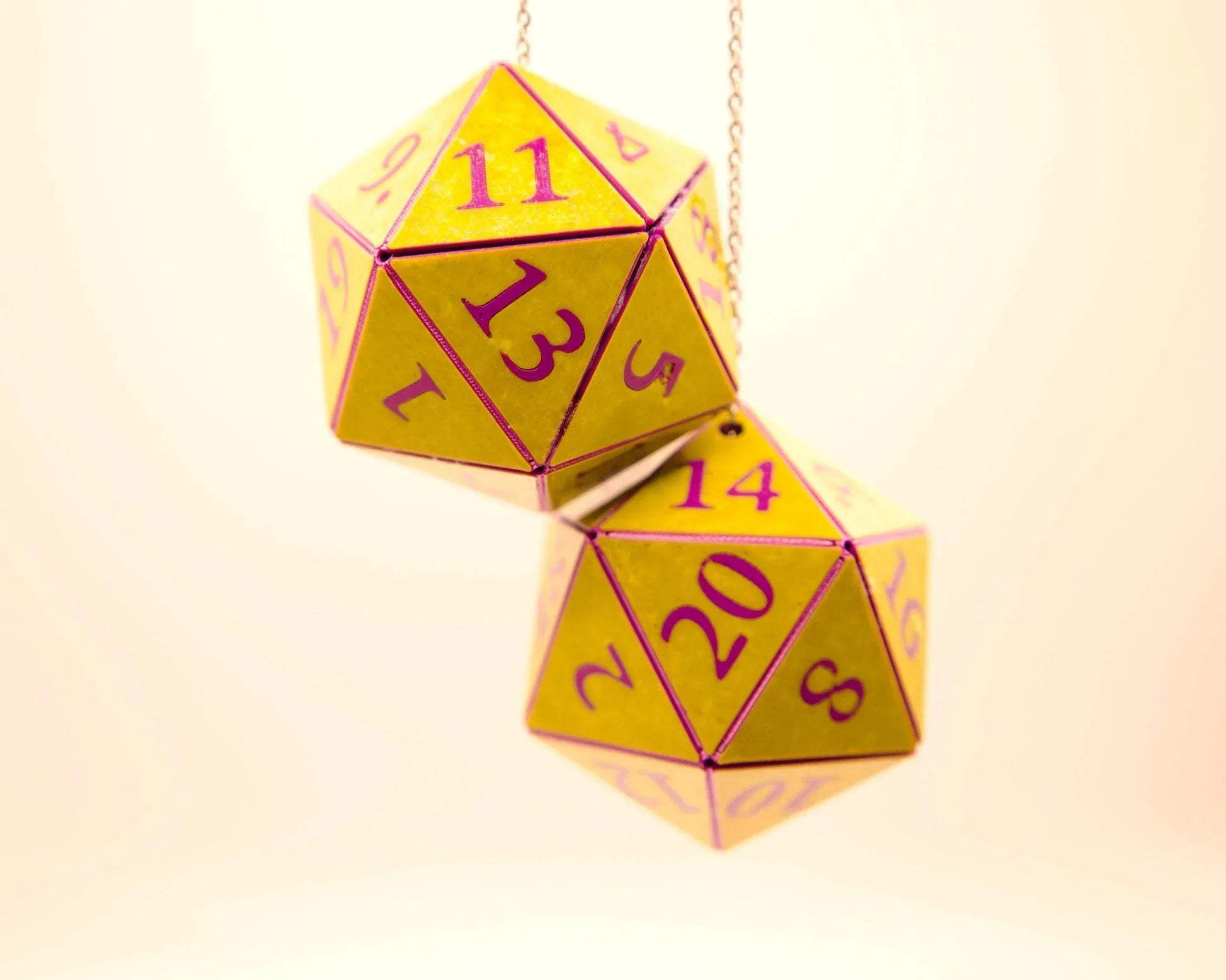 Yellow twenty-sided dice with purple numbers on a chain, car accessory for gamers.