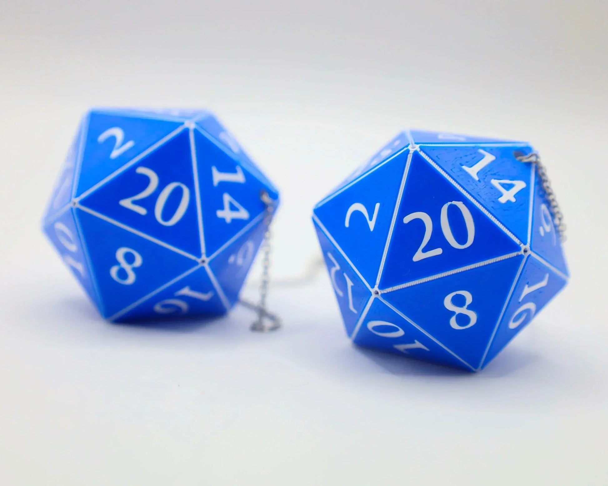 Pair of blue twenty-sided dice car charms with white numbers on a white background