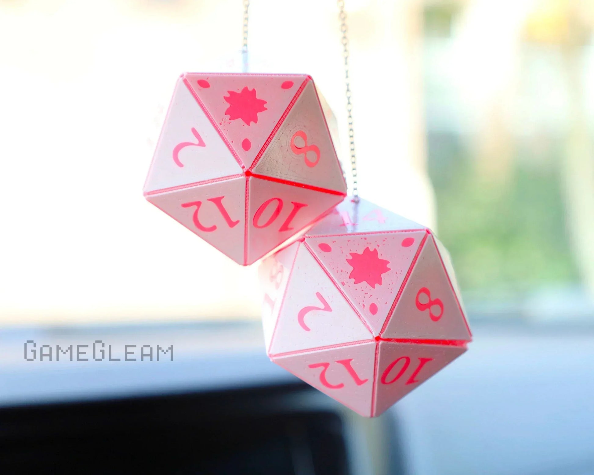 Pink twenty-sided dice car charm hanging from rearview mirror, handmade gamer accessory