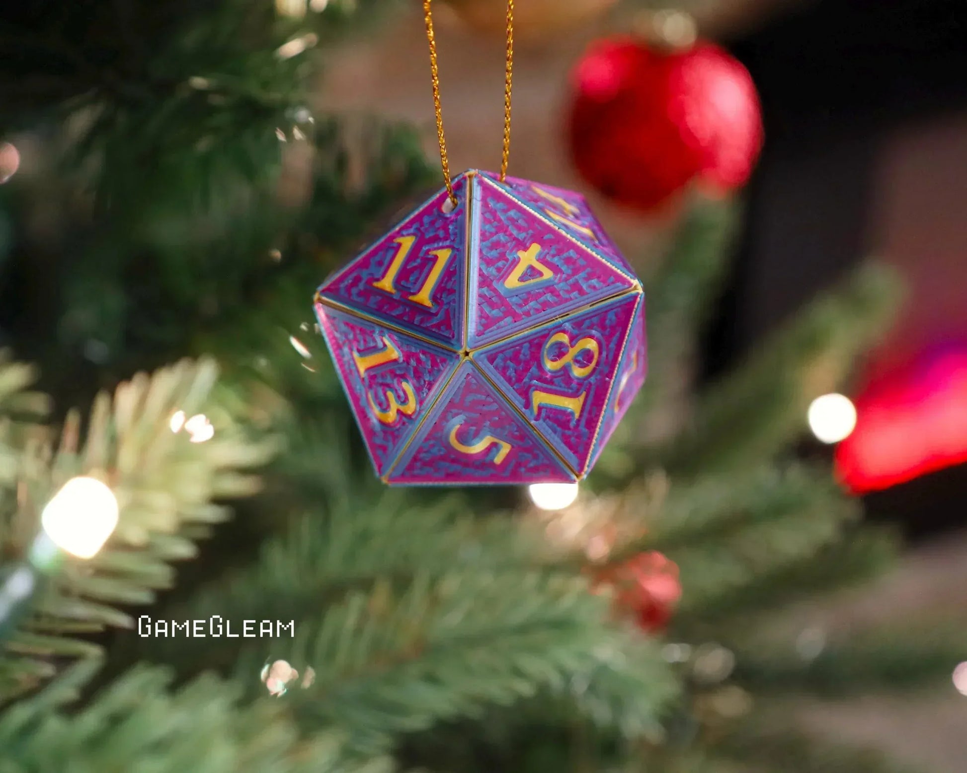 Colorful handmade twenty-sided dice ornament hanging on a Christmas tree