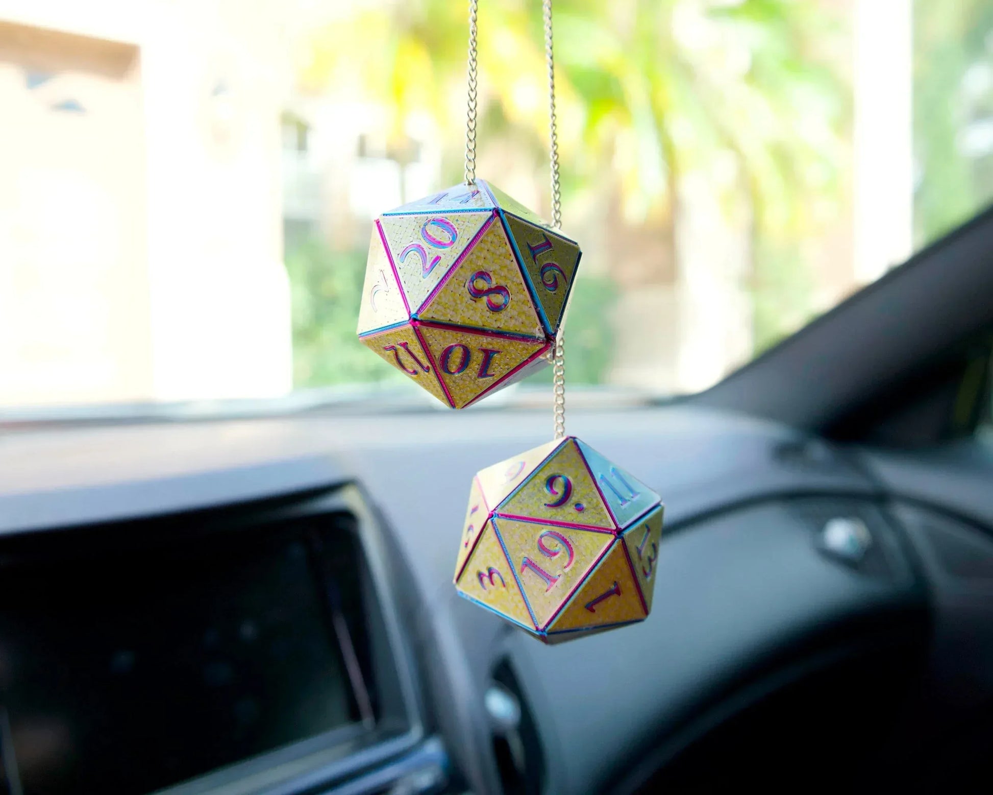 Holographic twenty-sided dice car charm hanging in a vehicle, colorful gamer accessory