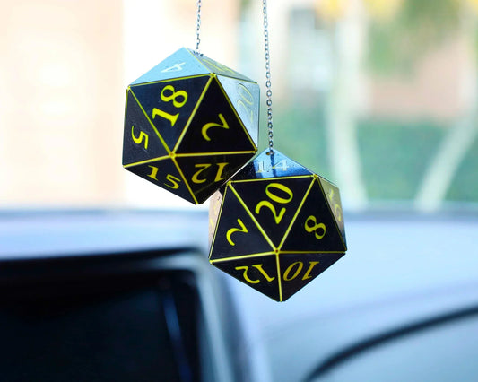 Black and yellow twenty-sided dice hanging from a car rearview mirror, used as car charm.