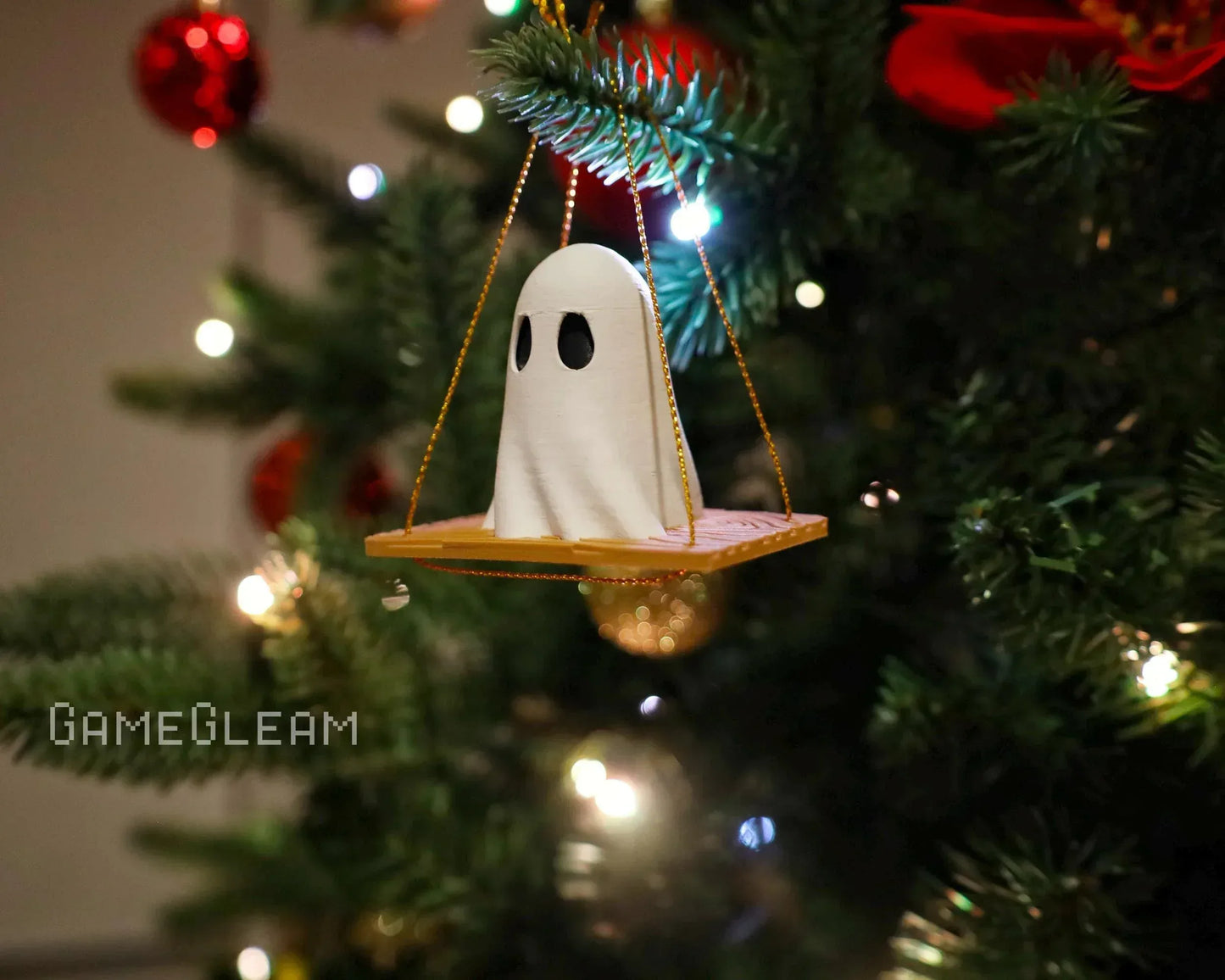 Handmade ghost ornament on a swing, hanging on a decorated Christmas tree