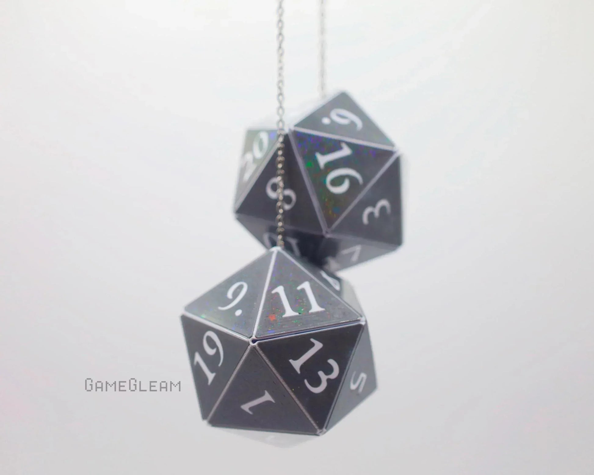 Hanging holographic black twenty-sided dice charms with white numbers on a chain