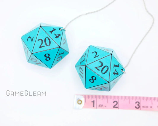 Pair of large teal 20-sided dice on a chain, tabletop game accessory, next to measuring tape.