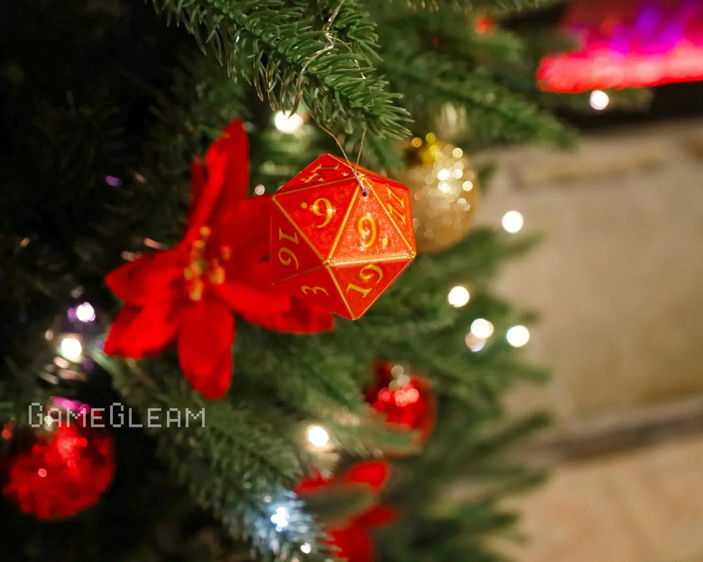 Red twenty-sided dice ornament hanging on decorated Christmas tree with festive lights