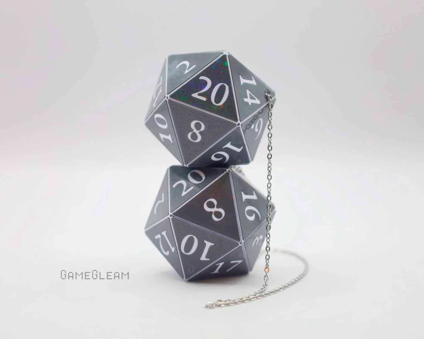 Pair of holographic black twenty-sided dice hanging as car mirror accessory with chain