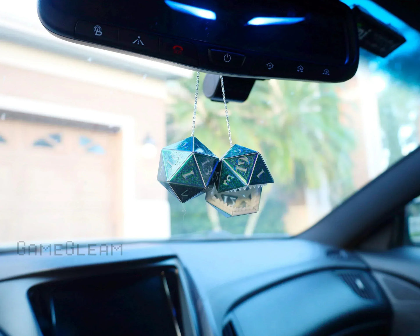 Holographic twenty-sided dice car charm hanging from rearview mirror in vehicle interior