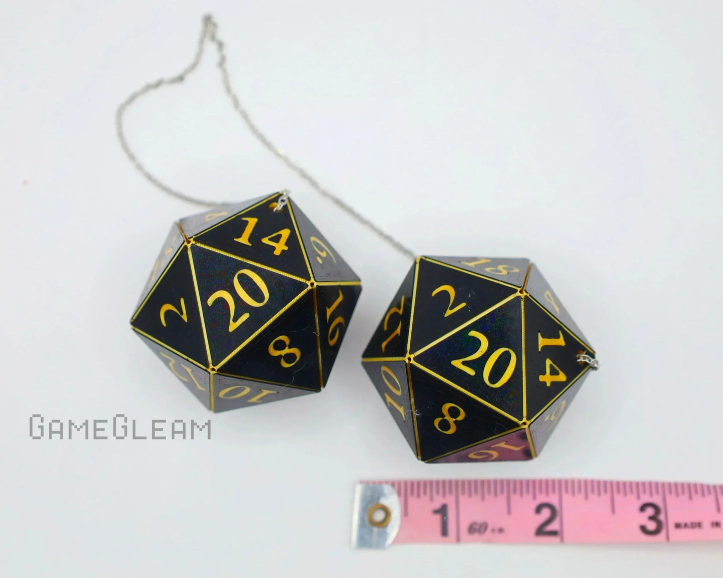 Pair of large black twenty-sided dice car charms with gold numbers and measuring tape