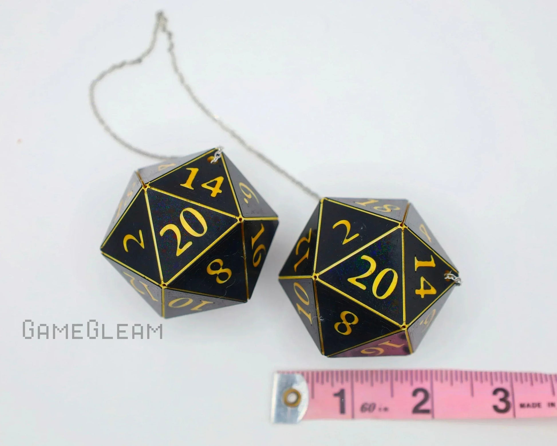 Pair of large black twenty-sided dice car charms with gold numbers and measuring tape