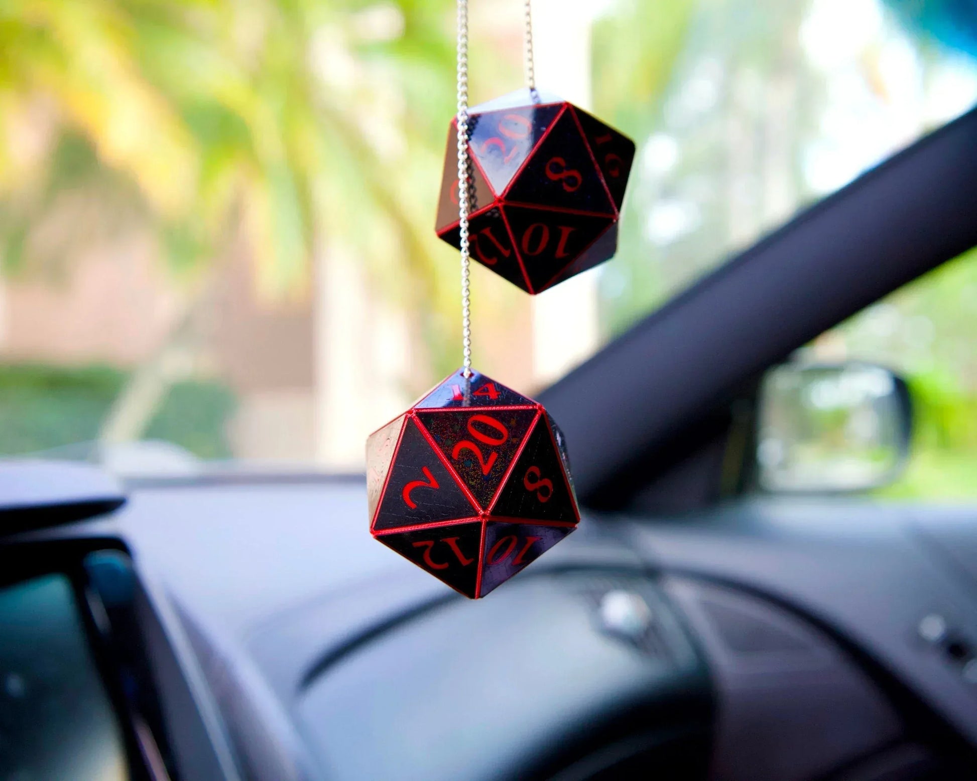 Black and red 20-sided dice hanging as car charm in vehicle interior