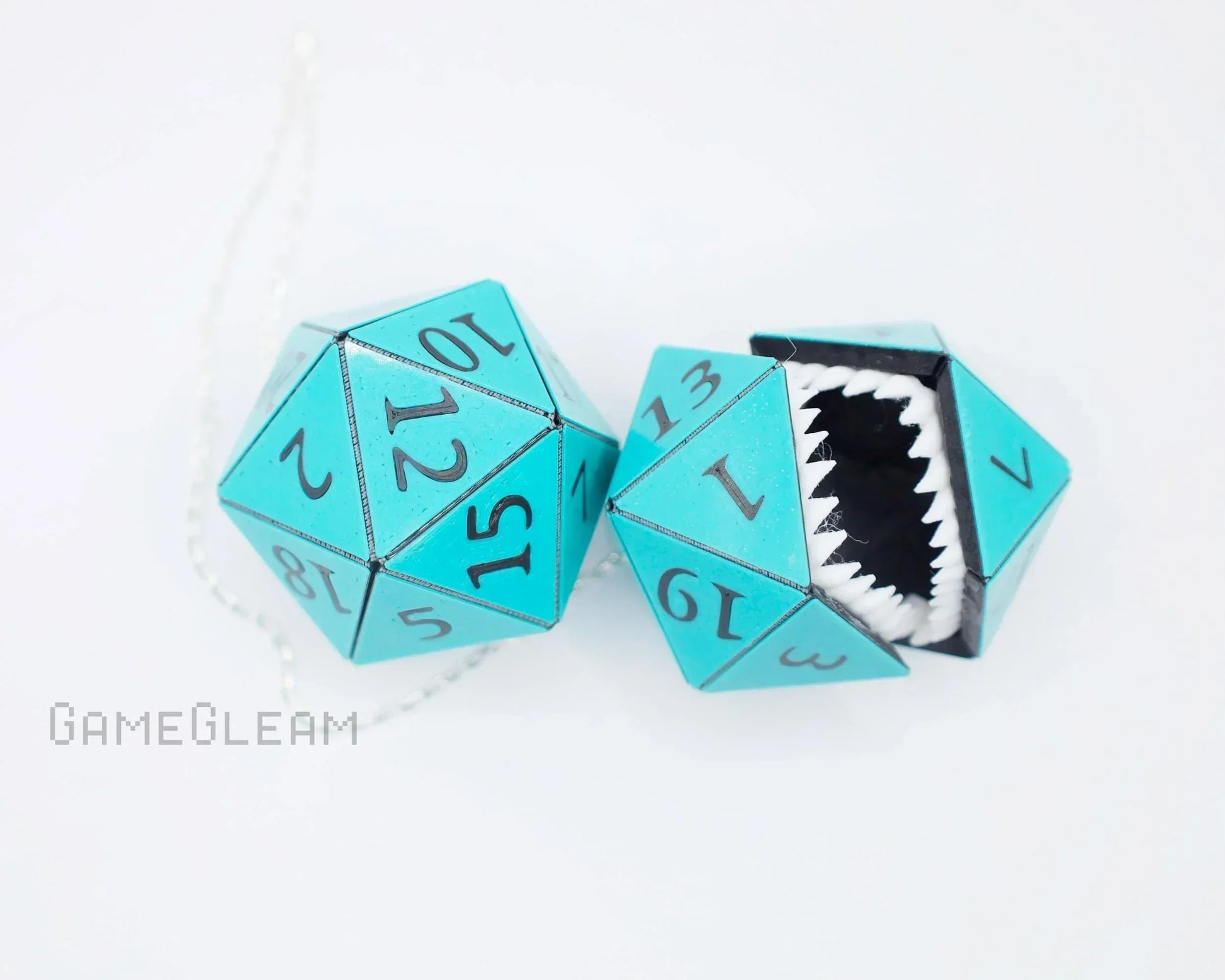 Teal twenty-sided dice car charm with numbers and one die featuring sharp teeth opening.