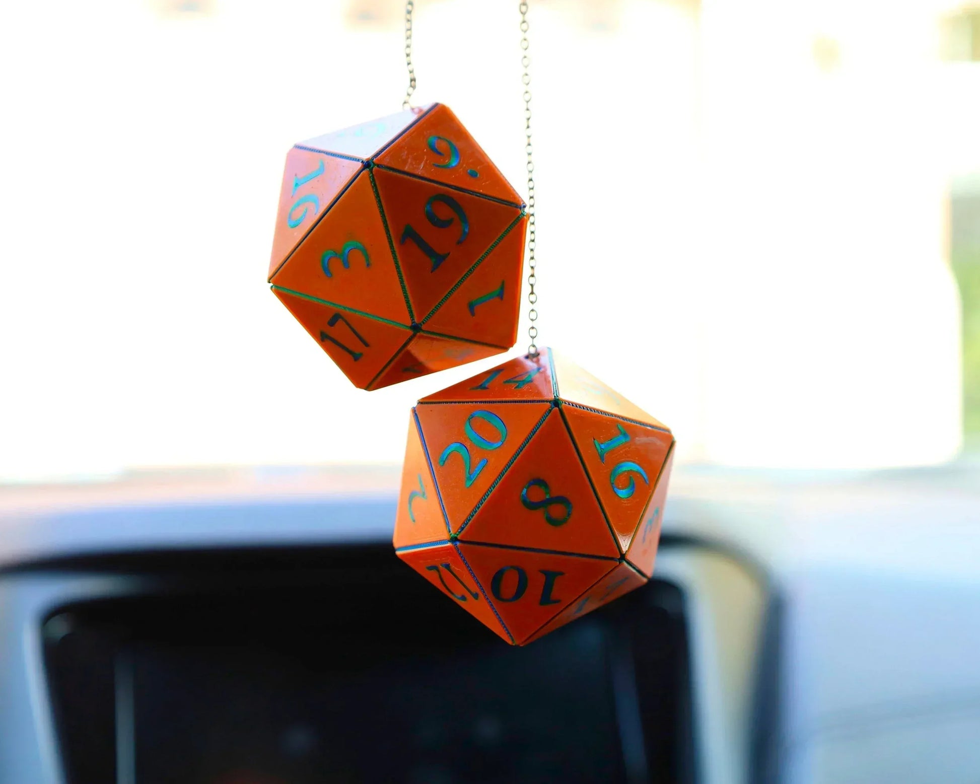 Orange twenty-sided dice car mirror charm for RPG gamers, hanging in vehicle interior.