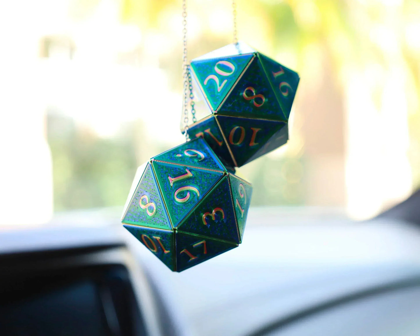 Holographic green D20 dice car charm hanging from rearview mirror