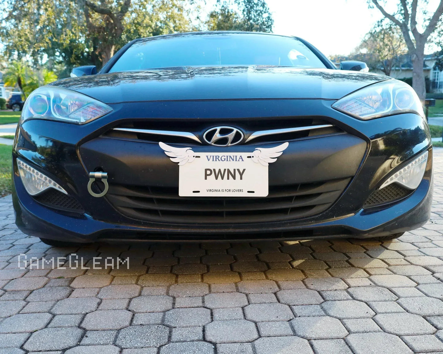 Front view of black Hyundai car with custom license plate reading PWNY and wing decal.