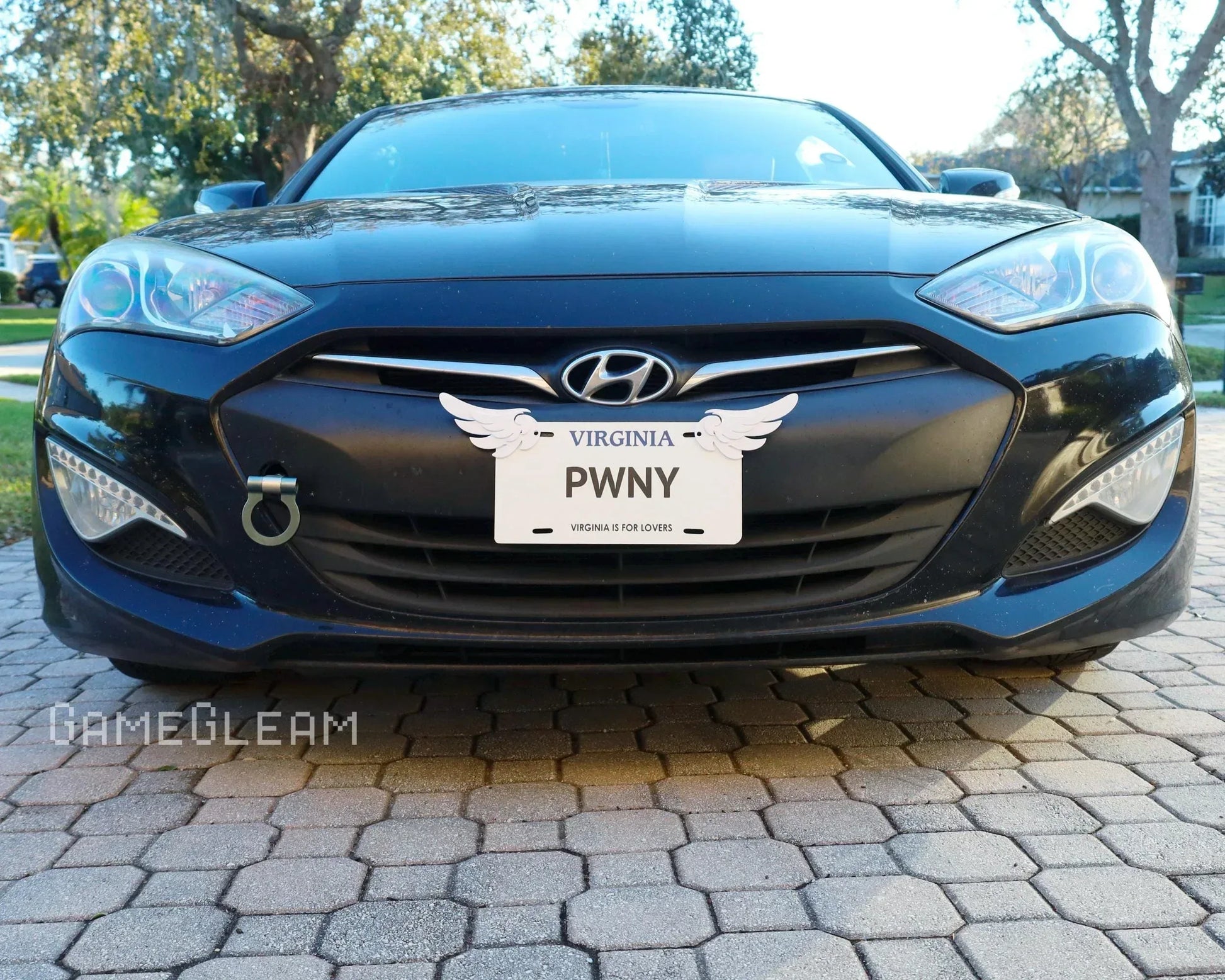Front view of black Hyundai car with custom license plate reading PWNY and wing decal.