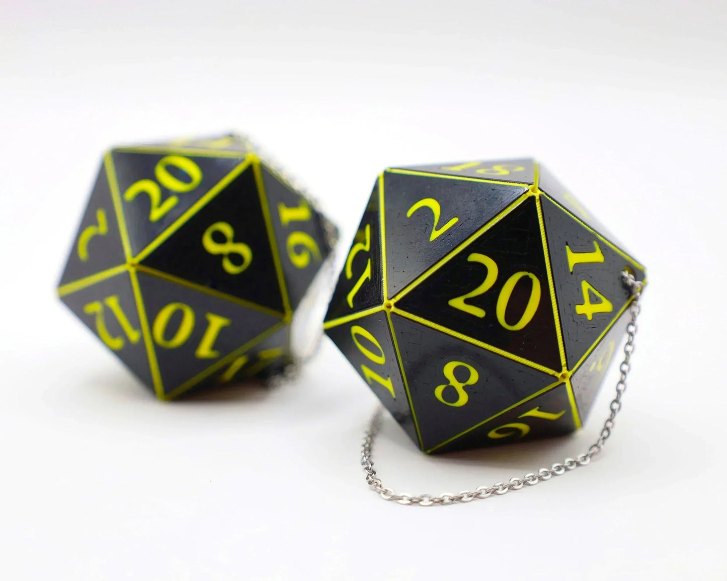 Black and yellow 20-sided gamer dice with chains, car accessory for tabletop RPG fans