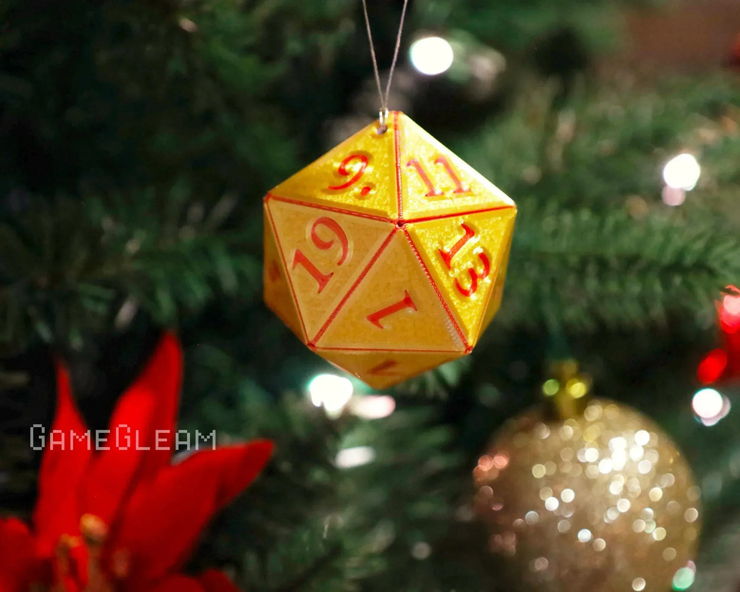 Yellow twenty-sided dice ornament with red numbers hanging on a Christmas tree