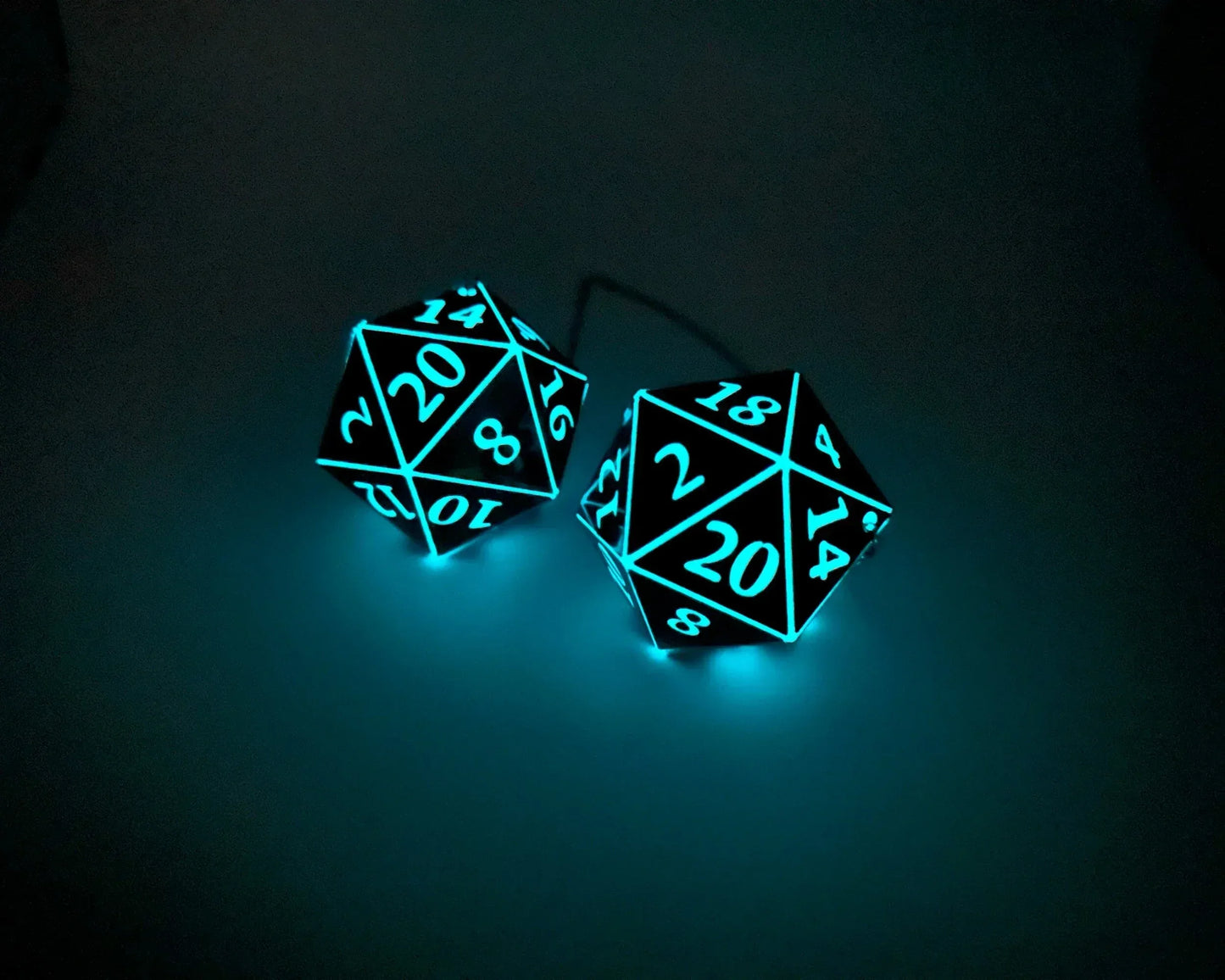 Glowing blue 20-sided dice car charm in a dark setting, handmade gamer gift