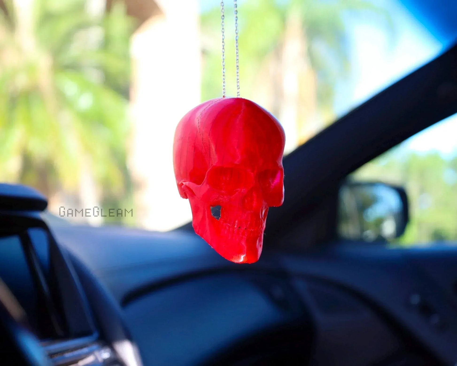 Red skull car charm hanging on rearview mirror in a car interior, handmade gamer gift