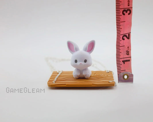 Cute small white bunny figurine on wood-patterned base with measuring tape for scale