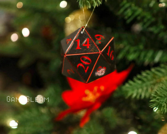 Black and red 20-sided dice ornament hanging on a Christmas tree with festive lights.
