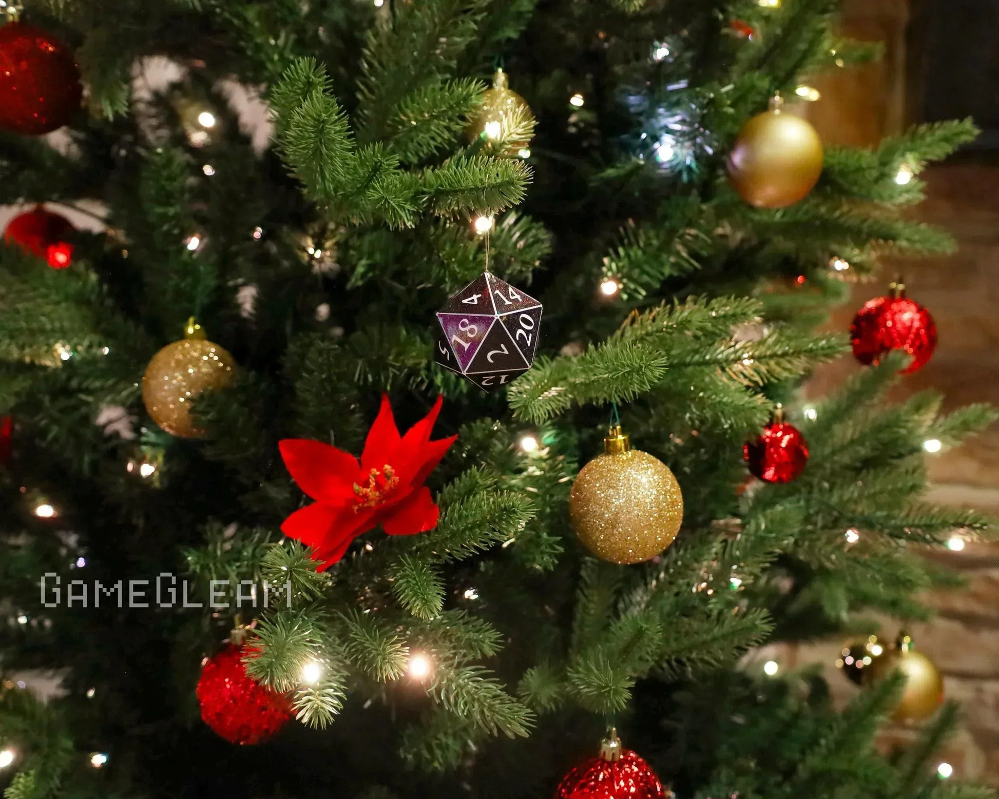 Christmas tree with lights, red and gold ornaments, and a black twenty-sided dice decoration