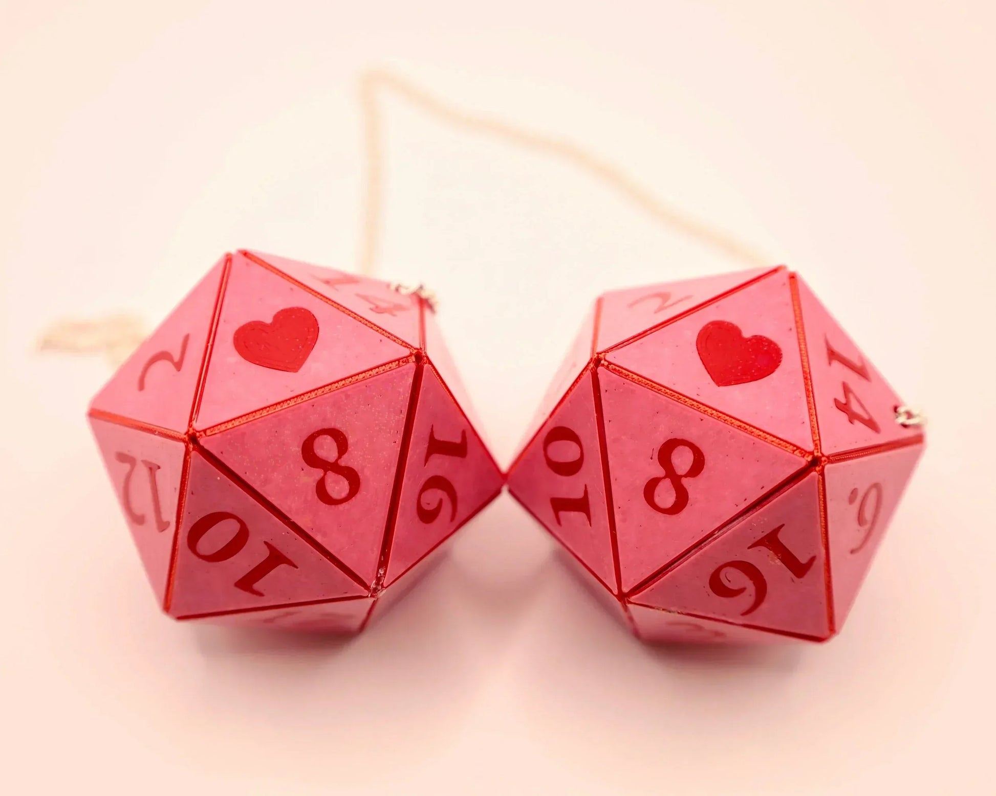 Handmade pink twenty-sided dice car charm with red numbers and heart symbols