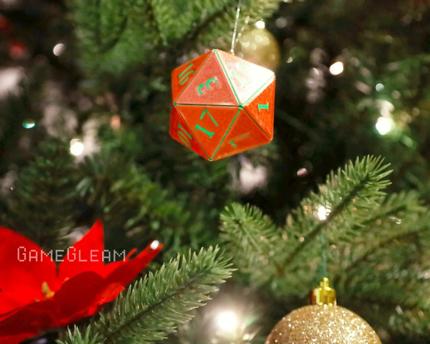 Red holographic twenty-sided dice ornament hanging on a decorated Christmas tree.