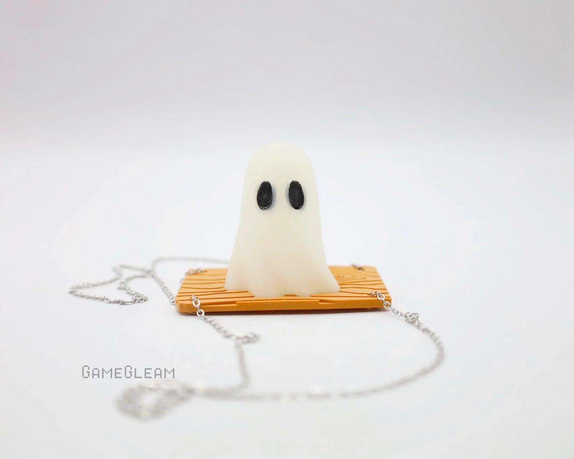 Handmade ghost charm with black eyes on orange base, silver chain, gamer accessory