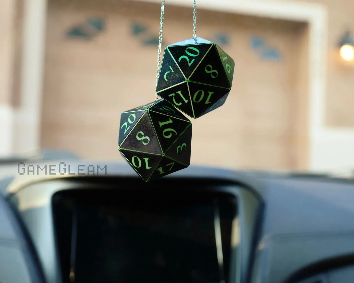Holographic green 20-sided dice car charm hanging from a rearview mirror
