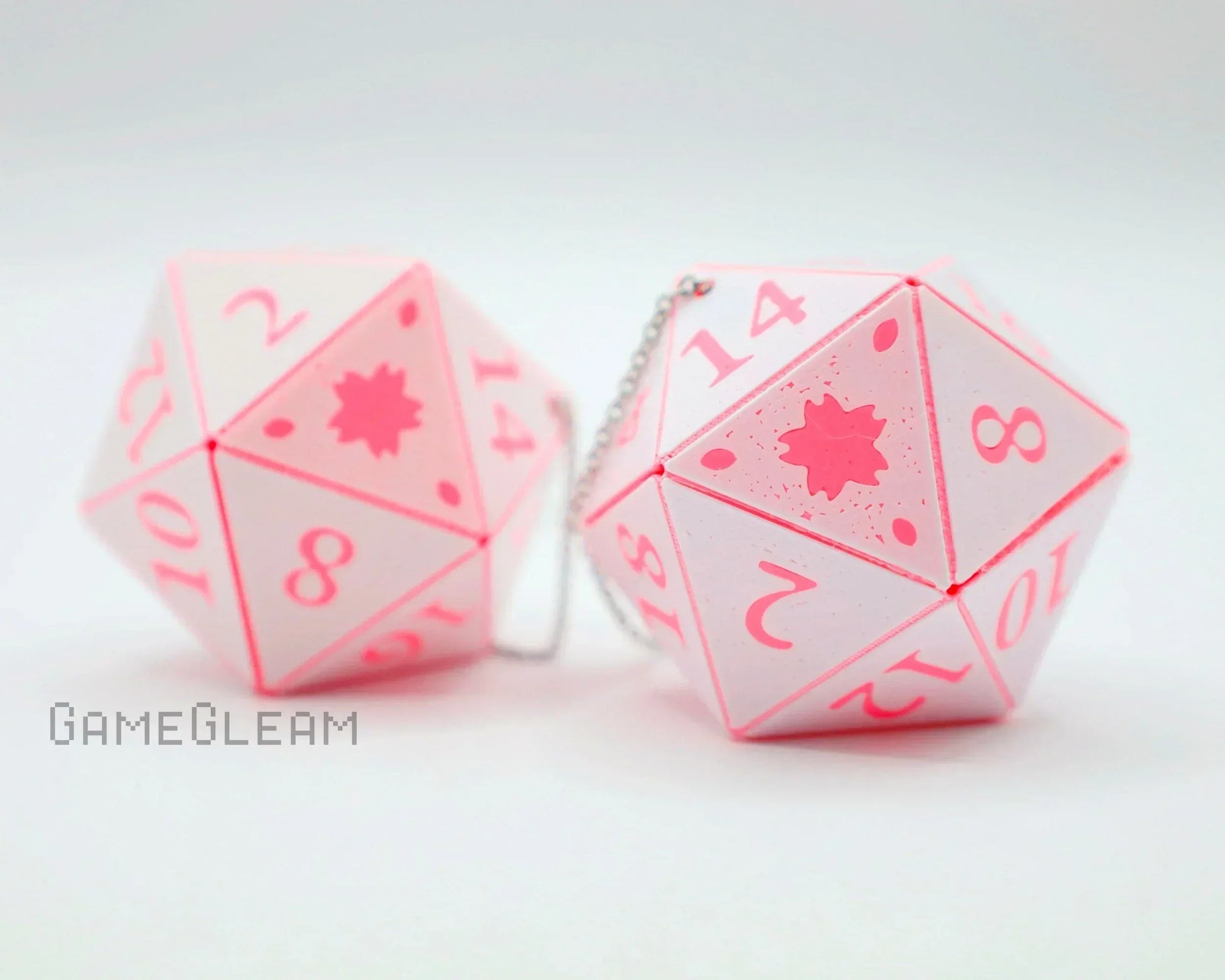 Pair of pink and white handmade 20-sided dice car charms with engraved numbers.