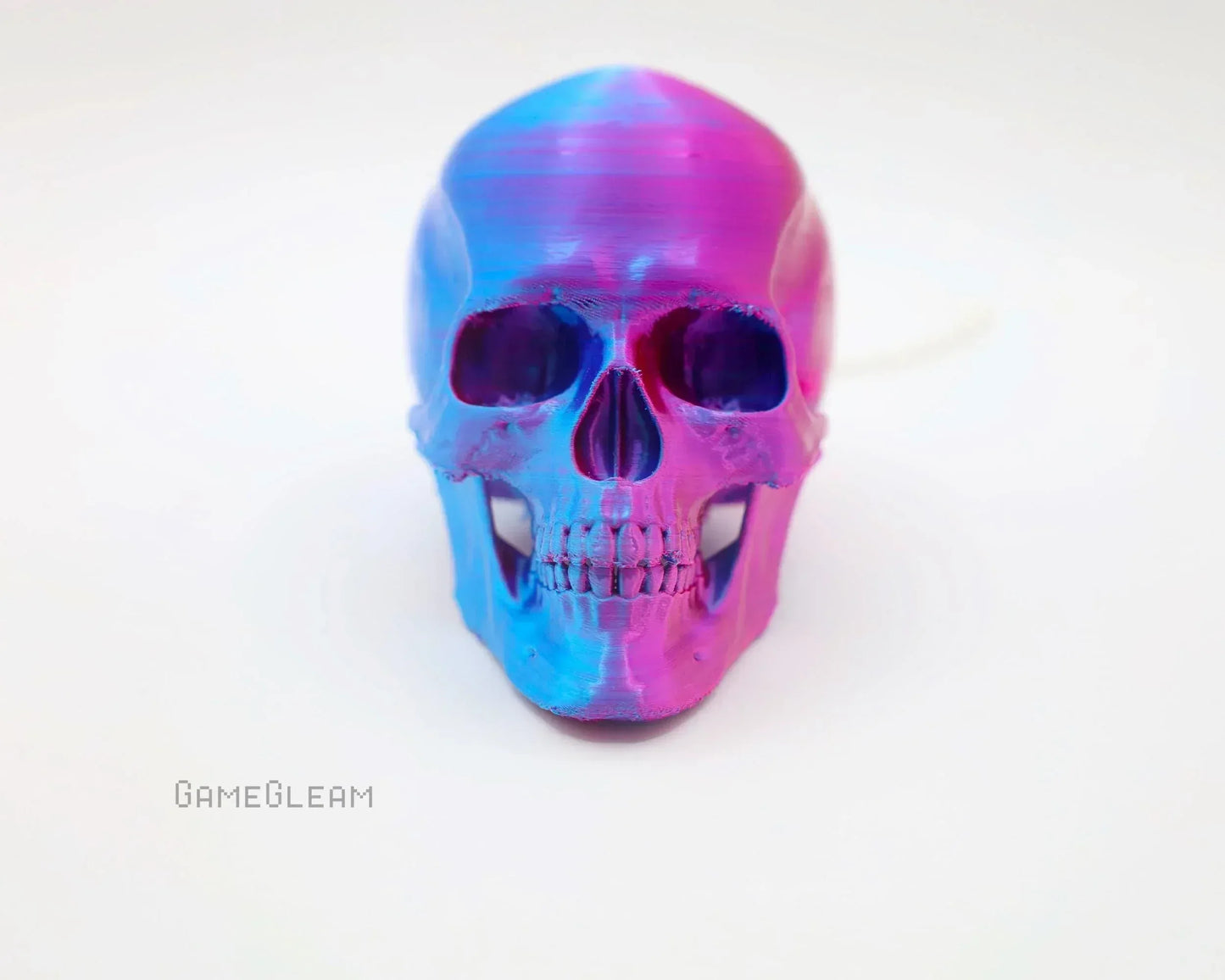 Iridescent pink and blue resin skull decor for gamers on a white background