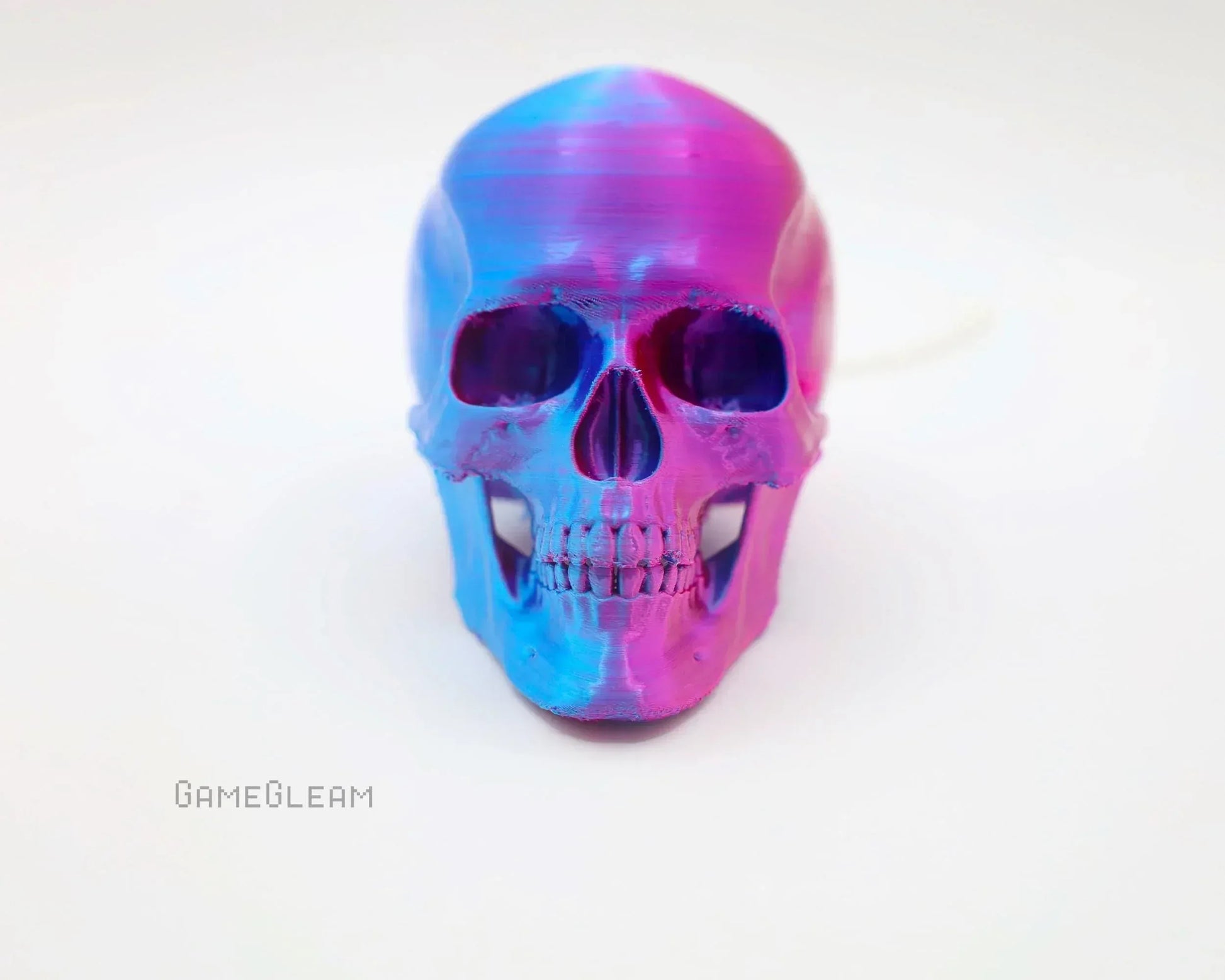 Iridescent pink and blue resin skull decor for gamers on a white background