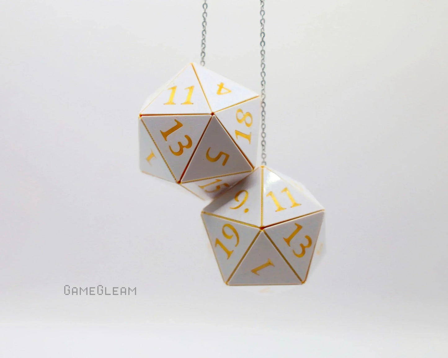 White and gold twenty-sided dice car charm on a chain, tabletop gaming accessory.