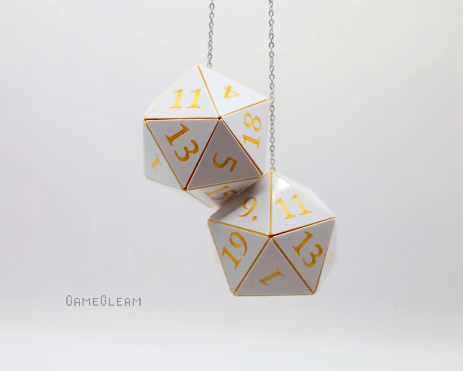 White and gold twenty-sided dice car charm on a chain, tabletop gaming accessory.