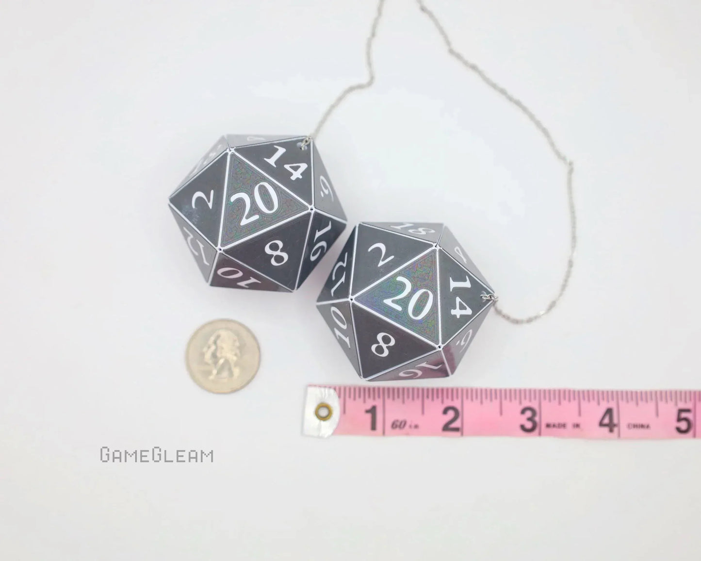 Holographic D20 dice car charm with measuring tape and coin for scale, white background